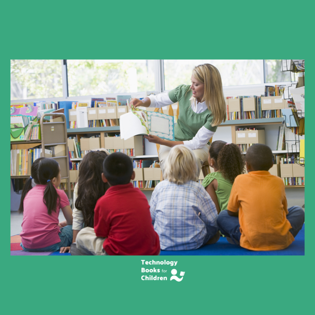 Children in a classroom with a teacher reading a tech themed book